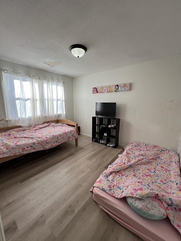 bedroom featuring hardwood / wood-style floors and a textured ceiling