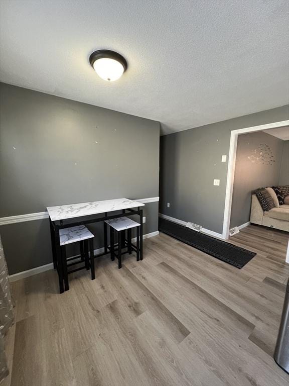 dining area featuring light hardwood / wood-style floors and a textured ceiling