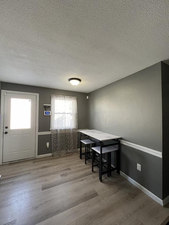 dining room featuring hardwood / wood-style floors and a textured ceiling