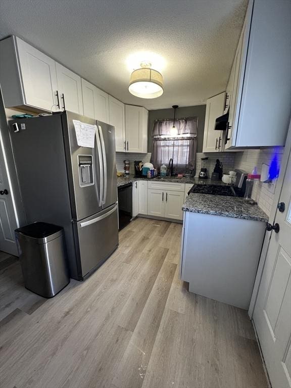 kitchen featuring white cabinetry, light wood-type flooring, stainless steel fridge, range, and a textured ceiling