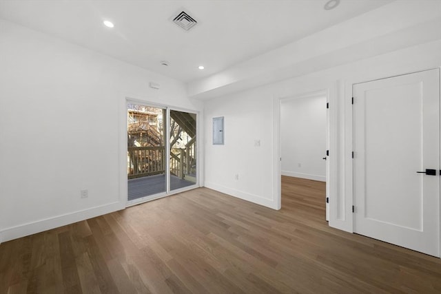 empty room with hardwood / wood-style flooring and electric panel