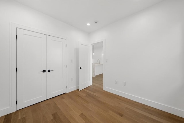 unfurnished bedroom with light wood-type flooring and a closet