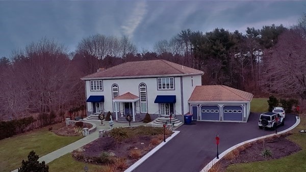 mediterranean / spanish home with a garage and a front lawn