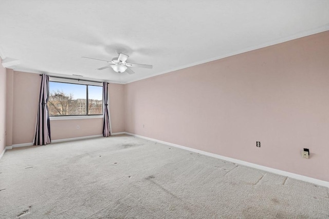 carpeted empty room featuring ceiling fan, ornamental molding, and baseboards