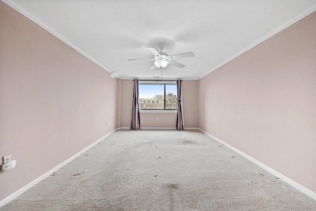 empty room featuring ornamental molding, light carpet, baseboards, and ceiling fan