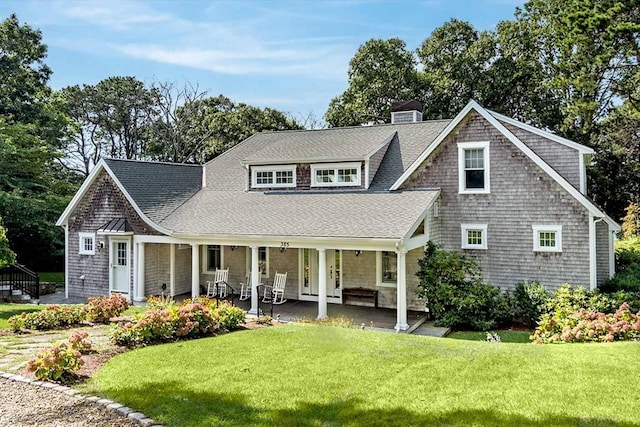 385 Barnes Rd, Oak Bluffs, MA 02557 - shingle-style home with roof with shingles, a front yard, and a chimney