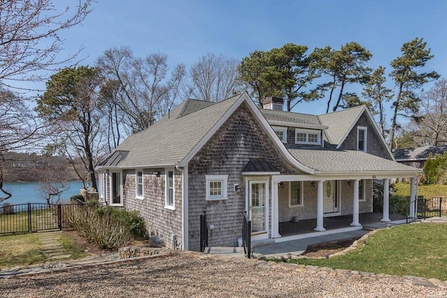 385 Barnes Rd, Oak Bluffs, MA 02557 - view of front of property with roof with shingles, a porch, and a chimney