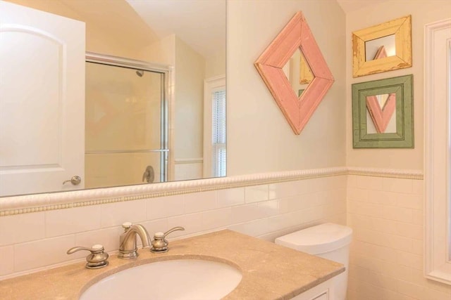 385 Barnes Rd, Oak Bluffs, MA 02557 - bathroom featuring tile walls, a shower stall, vanity, toilet, and wainscoting