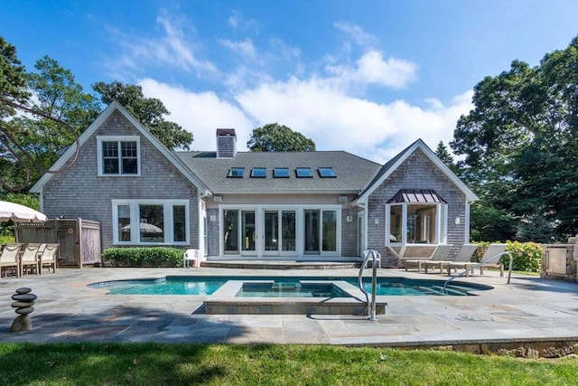 385 Barnes Rd, Oak Bluffs, MA 02557 - rear view of house with a patio, a chimney, a pool with connected hot tub, fence, and a shingled roof