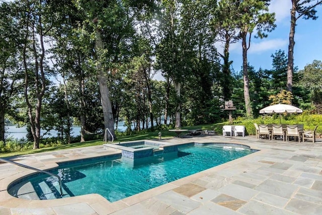 385 Barnes Rd, Oak Bluffs, MA 02557 - view of swimming pool with a patio area, a pool with connected hot tub, outdoor dining space, and view of wooded area