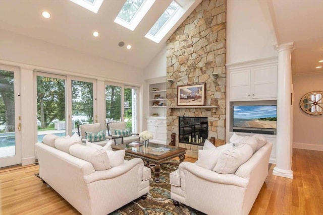 385 Barnes Rd, Oak Bluffs, MA 02557 - living room with a fireplace, light wood-style flooring, high vaulted ceiling, recessed lighting, and built in shelves