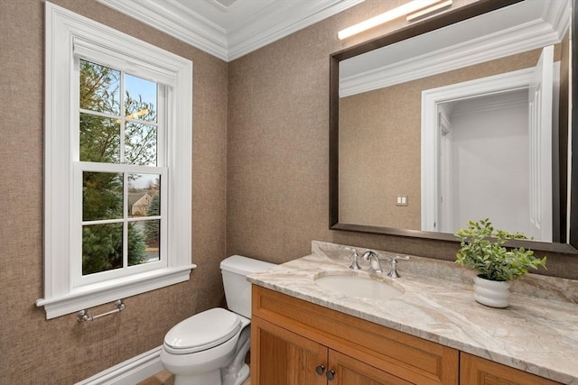 bathroom with toilet, a healthy amount of sunlight, ornamental molding, and vanity