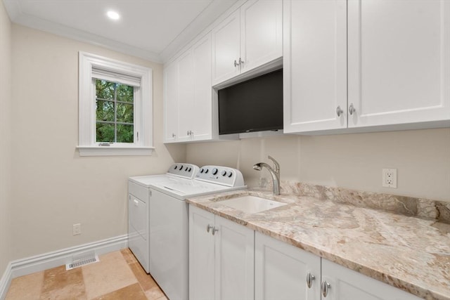 laundry room featuring cabinet space, baseboards, independent washer and dryer, crown molding, and a sink