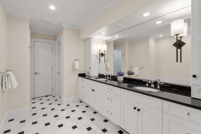 bathroom with crown molding, baseboards, a sink, and recessed lighting