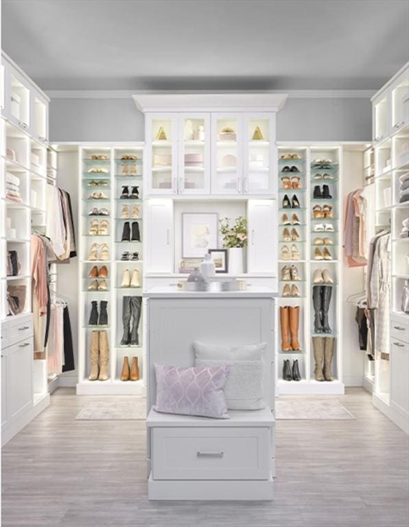 mudroom with light wood-style flooring and crown molding