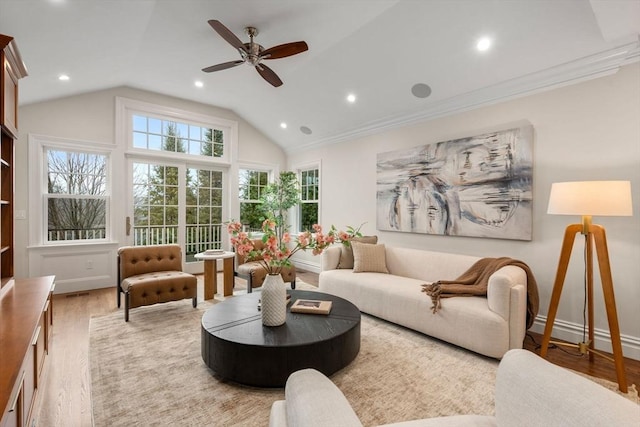 living room featuring light wood finished floors, a ceiling fan, vaulted ceiling, crown molding, and recessed lighting