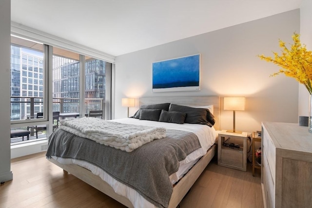 bedroom with light wood-style flooring and multiple windows