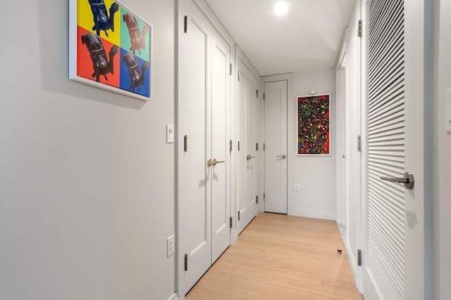 hallway with light wood finished floors and baseboards