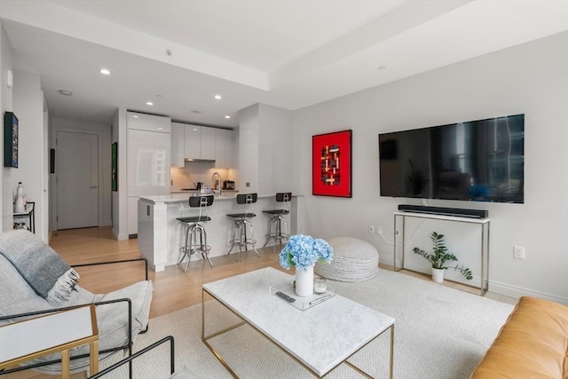 living area with recessed lighting, light wood-type flooring, and baseboards