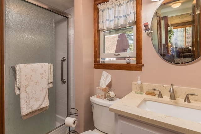 bathroom featuring toilet, a healthy amount of sunlight, and a shower with shower door