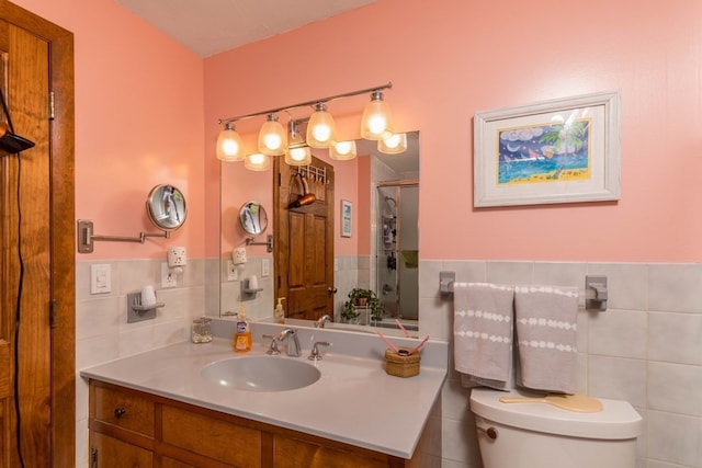 bathroom featuring toilet, vanity, tile walls, and a shower with door