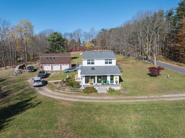 view of front of house with a porch, a front yard, and a garage