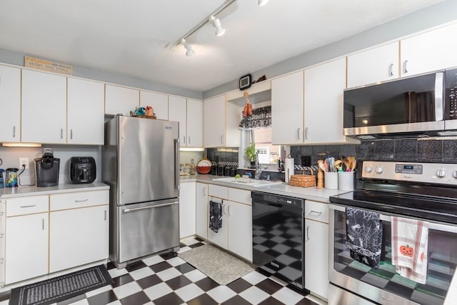 kitchen featuring white cabinetry, stainless steel appliances, decorative backsplash, and sink