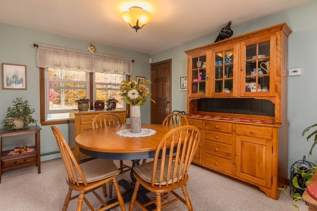 dining space with light carpet and a baseboard radiator