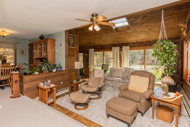 living room featuring wood walls, a skylight, light wood-type flooring, a baseboard heating unit, and ceiling fan