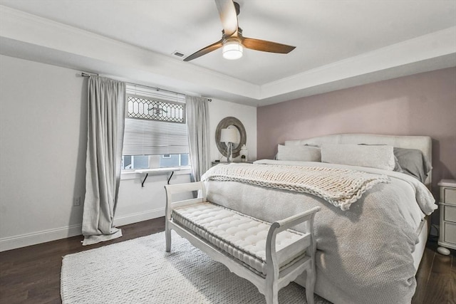 bedroom with a raised ceiling, ceiling fan, and dark hardwood / wood-style floors