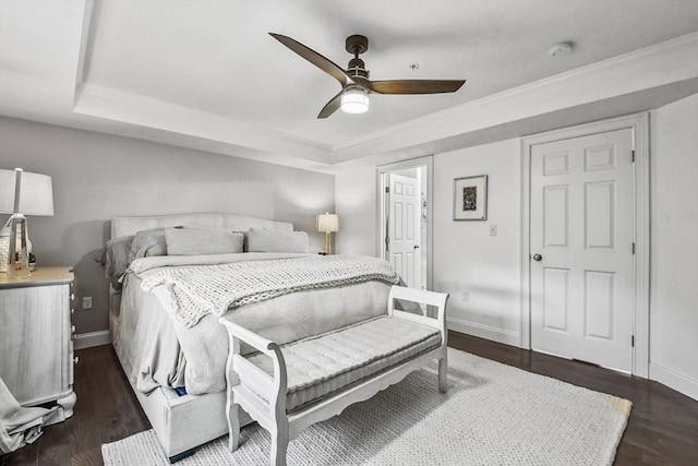 bedroom with ceiling fan, a raised ceiling, and dark hardwood / wood-style floors