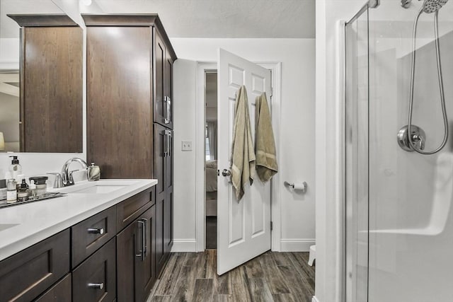 bathroom with a textured ceiling, a shower with door, vanity, and hardwood / wood-style flooring