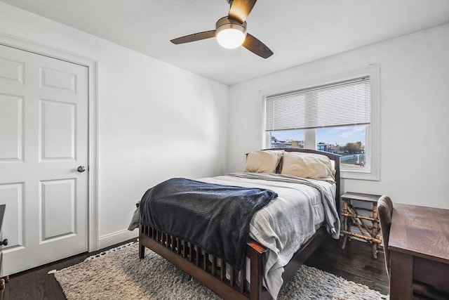 bedroom with dark hardwood / wood-style flooring and ceiling fan