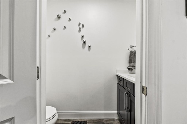 bathroom featuring toilet, vanity, and wood-type flooring