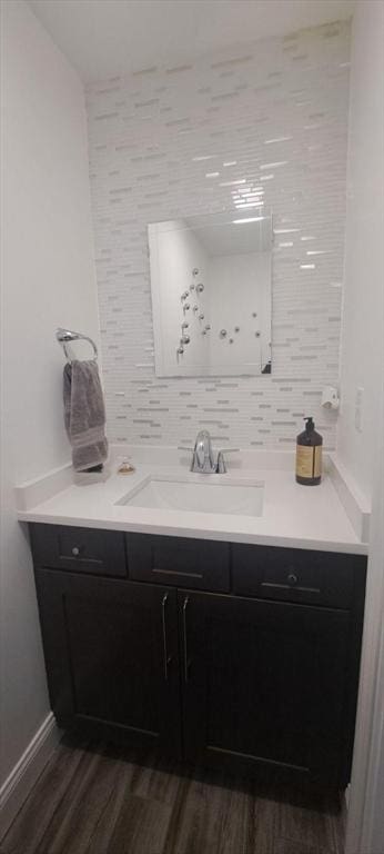 bathroom featuring wood-type flooring, vanity, and decorative backsplash