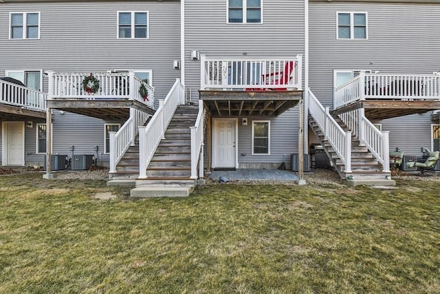 back of property featuring central air condition unit and a lawn