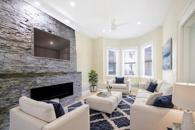 living area featuring ceiling fan, a fireplace, recessed lighting, and wood finished floors