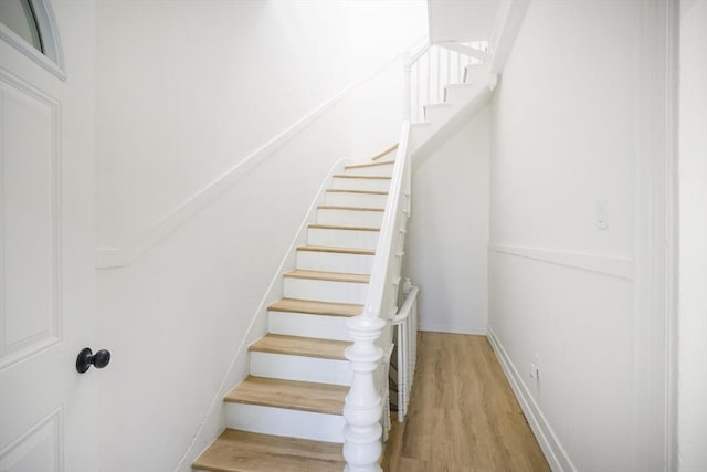 stairs featuring wood finished floors and baseboards