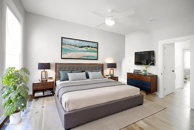 bedroom featuring light wood finished floors, baseboards, and a ceiling fan