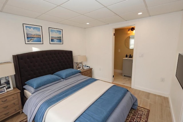 bedroom with a paneled ceiling, recessed lighting, baseboards, and wood finished floors
