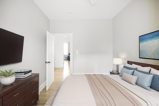 bedroom with light wood finished floors and baseboards