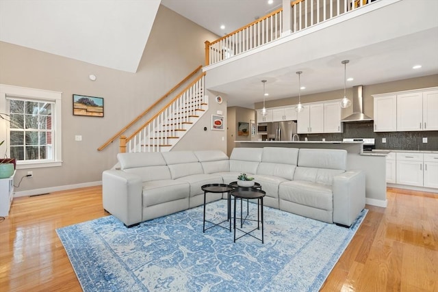 living room with a high ceiling and light wood-type flooring