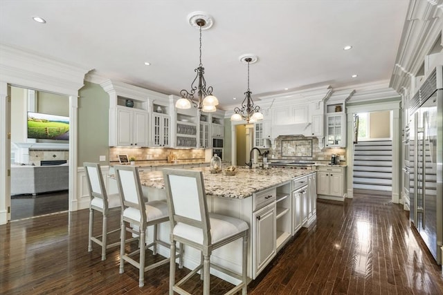 3 Newton Ln, Medway, MA 02053 - kitchen featuring a center island with sink, backsplash, a chandelier, crown molding, and dark wood-style flooring