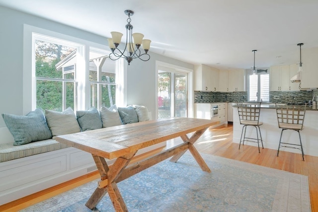 dining space with a notable chandelier and light hardwood / wood-style flooring