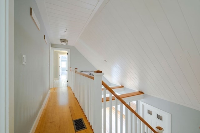 hallway with lofted ceiling and light hardwood / wood-style floors