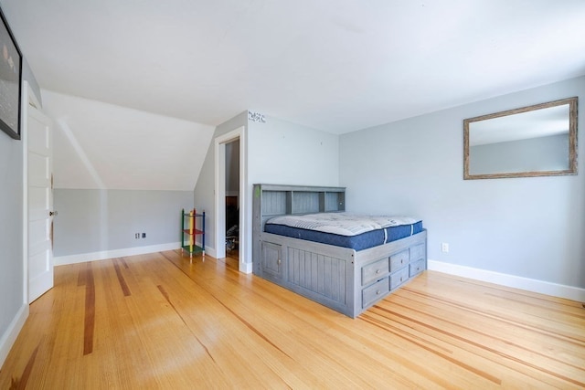 unfurnished bedroom featuring hardwood / wood-style flooring and lofted ceiling