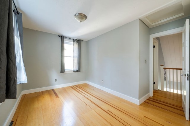 empty room featuring lofted ceiling and hardwood / wood-style floors