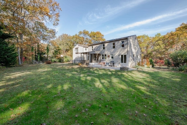 rear view of property with a patio and a lawn