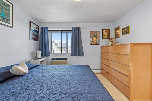 12 Pond Ln Unit 65, Arlington, MA 02474 - bedroom featuring a wall mounted air conditioner, light wood-style floors, and a baseboard heating unit