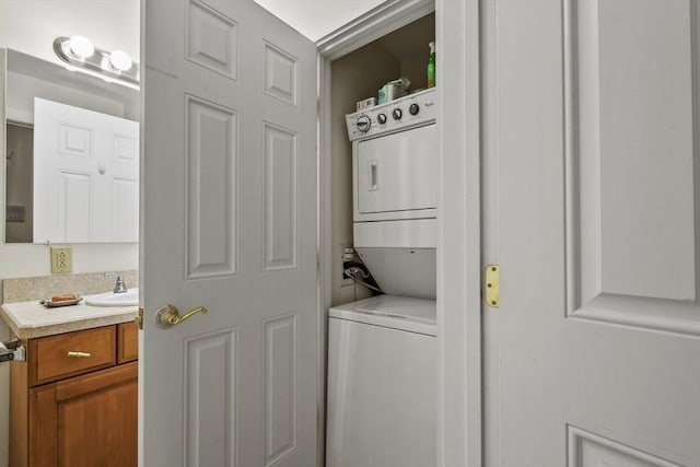 laundry room with a sink, stacked washer / dryer, and laundry area